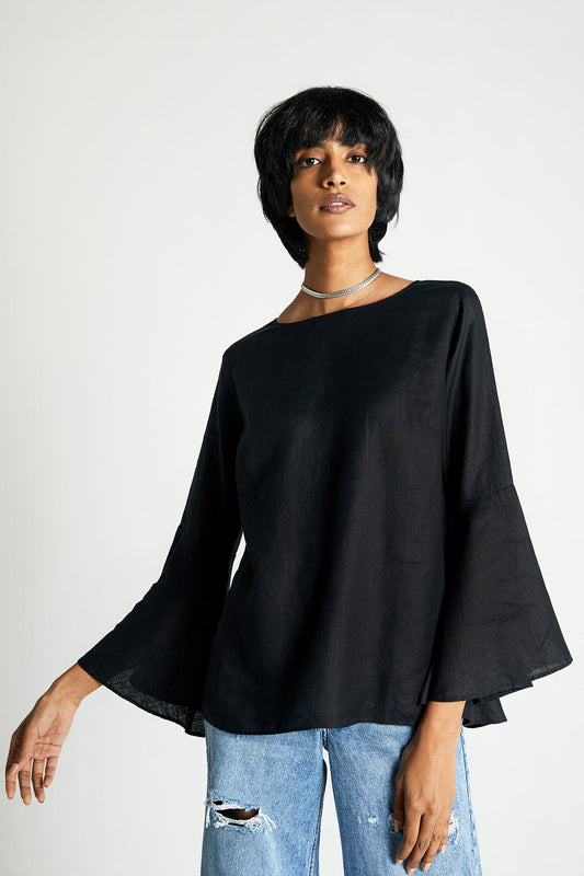 Person wearing a black top and blue jeans on a white background